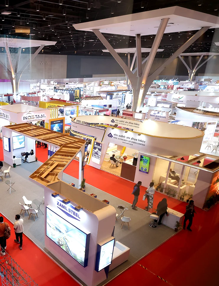 Aerial view of a large trade show hall with rows of branded exhibitor booths and visitors walking the aisles