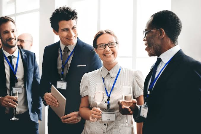 Badged delegates in conversation during a conference networking break